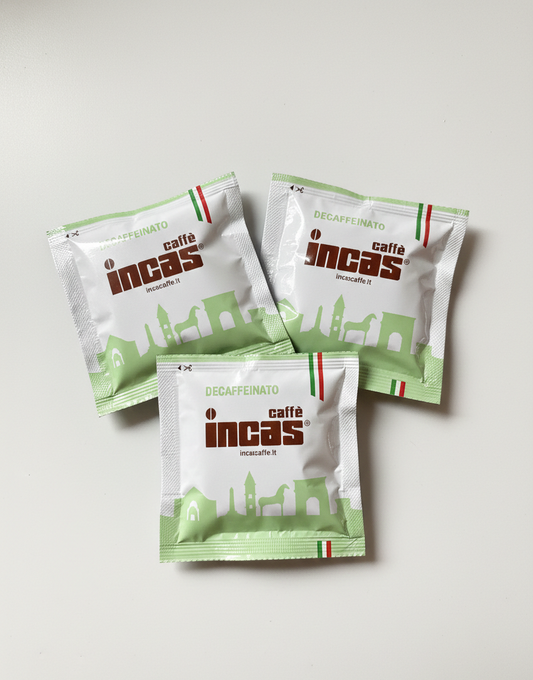 Trois dosettes de café Incas décaféiné en sachets verts, vues de haut