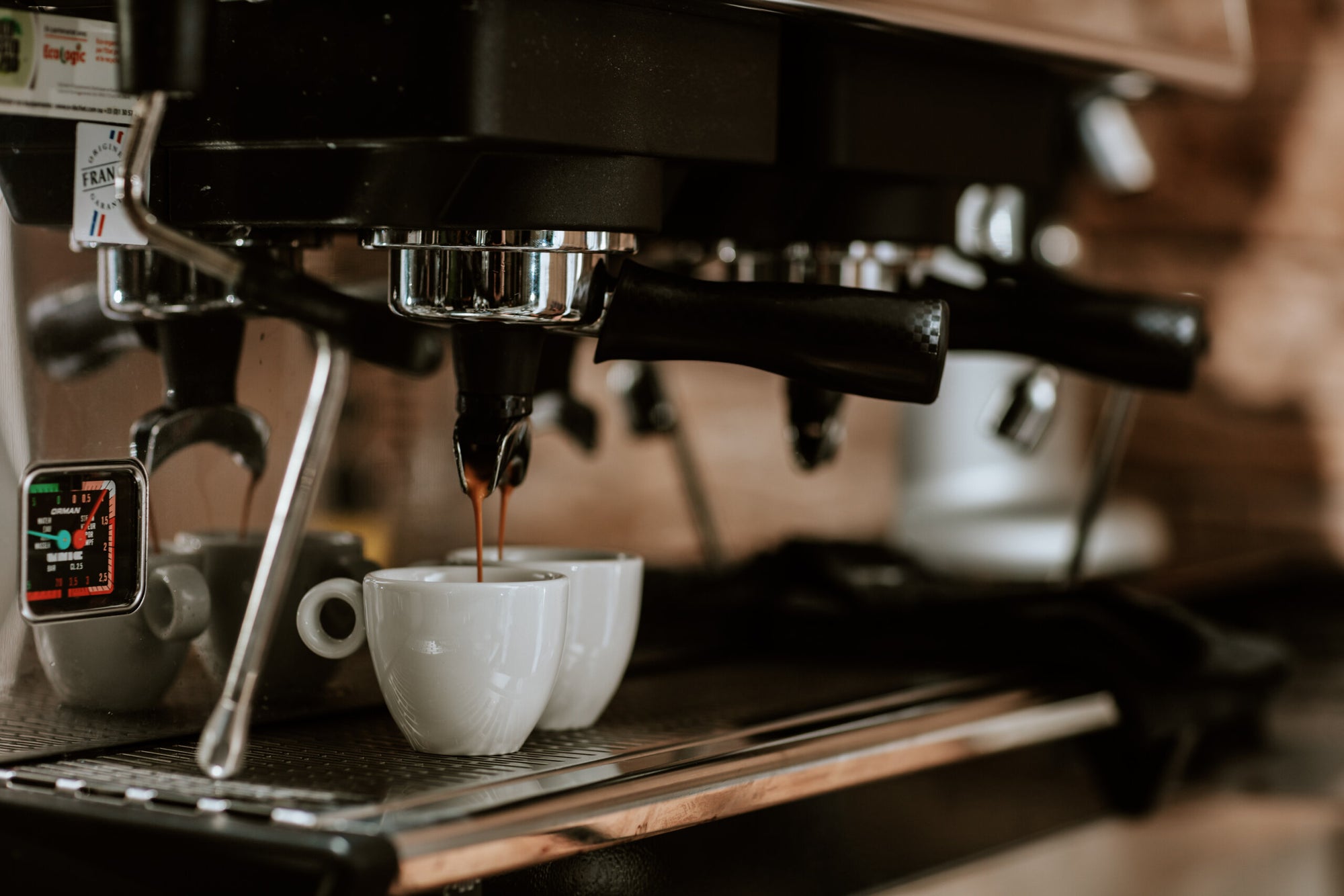Extraction d'un espresso dans une tasse blanche sous une machine professionnelle UNIC dans un café